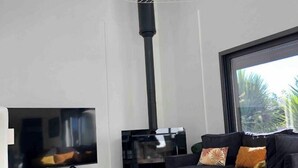 A modern living room with a large flat-screen TV, a fireplace, and a comfortable sofa.