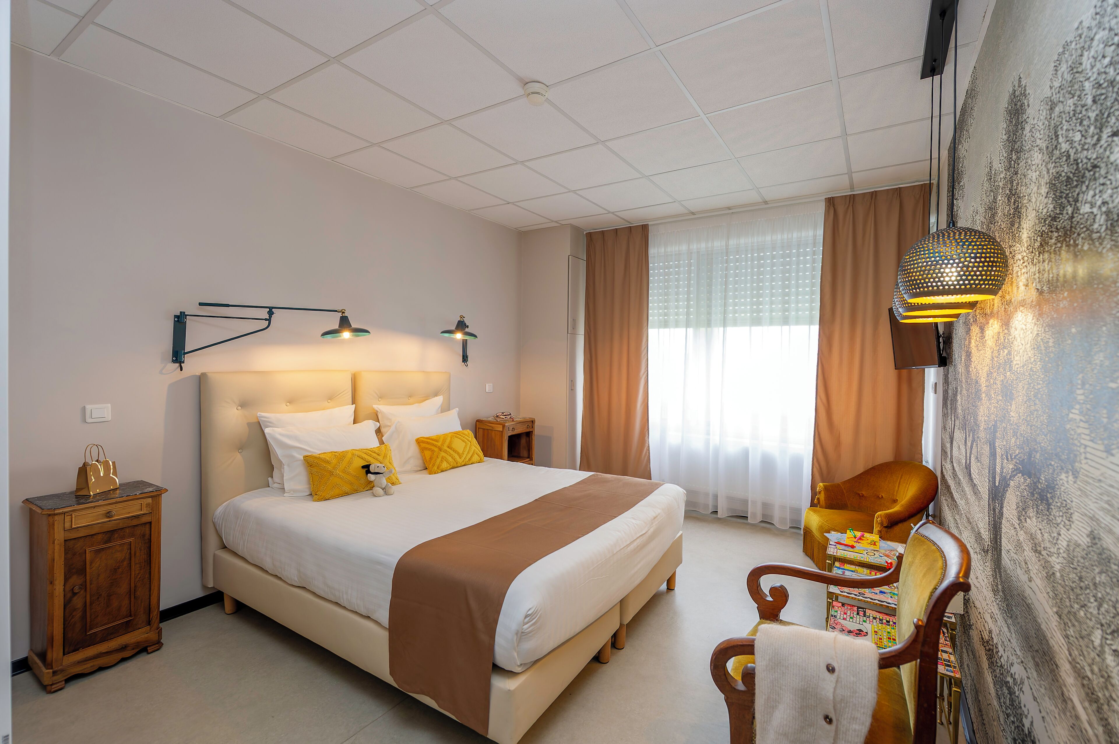 A hotel room with a large bed, bedside tables, a chair, and a wall-mounted lamp.