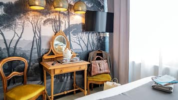 Una habitación con una cama, un escritorio de madera con un espejo, una silla y una mesa con tetera y tazas.