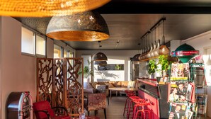 A cozy interior with a bar area, seating, and magazines. - Hôtel Le Grand Barnum (Francheville)