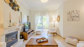 Una sala de estar moderna con chimenea, televisor y un área de estar confortable.