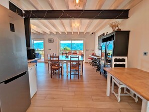 A modern kitchen with a built-in refrigerator, wooden dining table, and chairs.