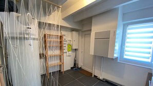 A kitchen with a wooden ladder, a white refrigerator, and a window with blinds. - Spacious cottage for 10 in Vagney - Sauna, games, near Gérardmer (Vagney)