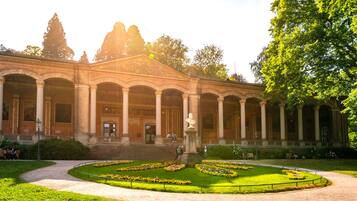 A classical building with a central courtyard, columns, and a statue.