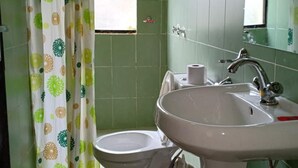 A bathroom with a toilet, sink, and shower curtain. - Mathioya River Lodge (Gacharageini)