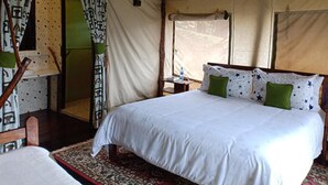 A tent-style room with a bed, curtains, and a window. - Mathioya River Lodge (Gacharageini)