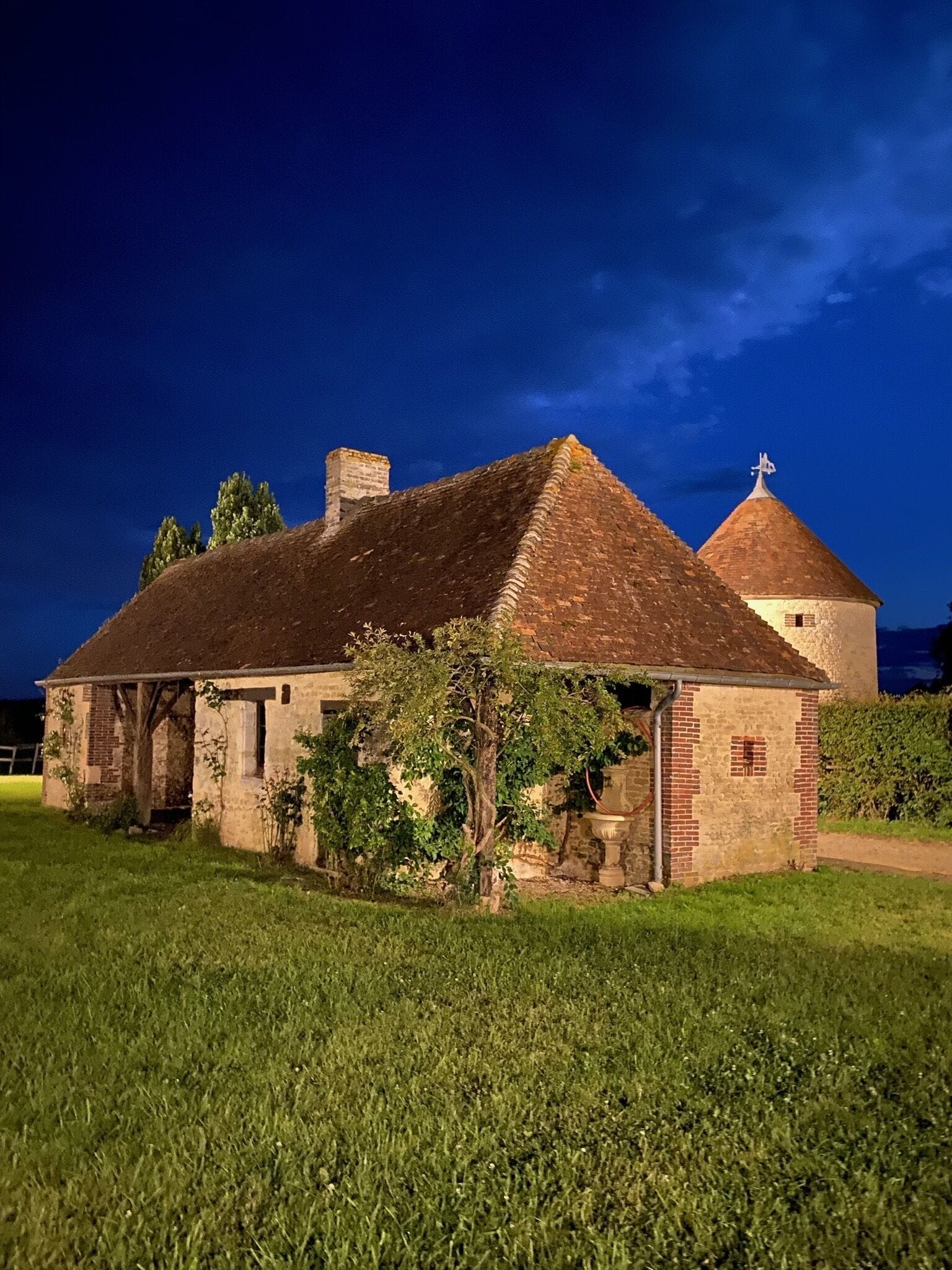 A historic building with a brick facade, a tiled roof, and a circular tower.