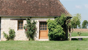 Una casa de piedra con techo de tejas, puerta de madera y ventanas.