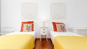 Une chambre d’hôtel avec deux lits, une table de chevet et une chaise.