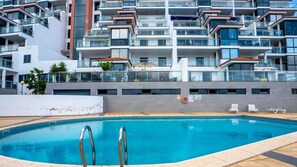 Un edificio moderno con piscina, balconi e un galleggiante.