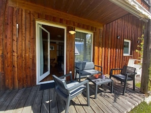 A wooden deck with outdoor seating and a glass door leading inside. - Presseggersee, Large 5 p. Apartment (Hermagor)