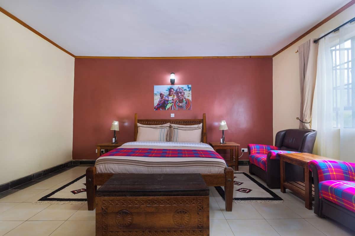 A bedroom with a bed, bedside tables, a chair, and a window.