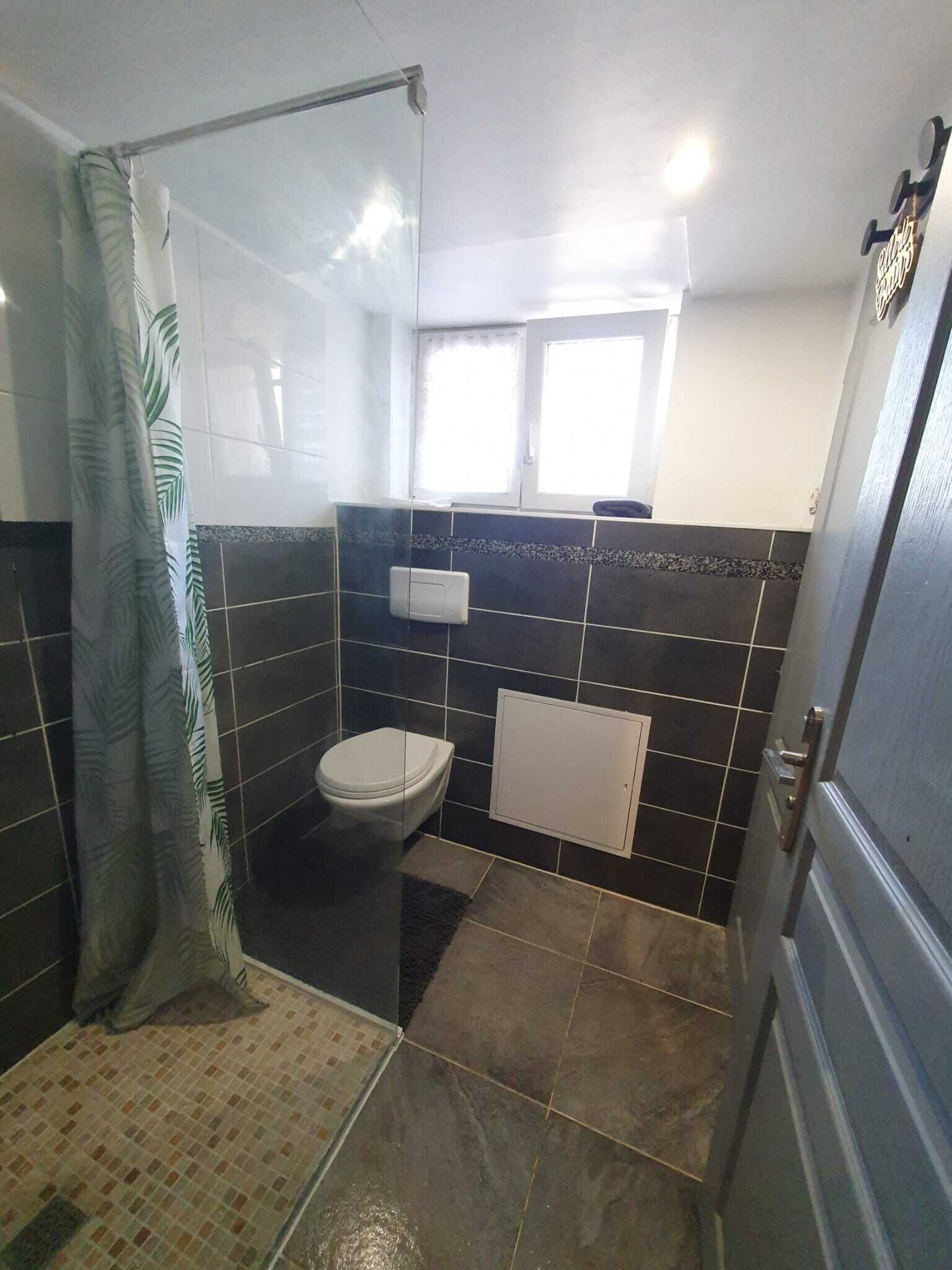 Un baño con cabina de ducha de vidrio, inodoro y lavabo.