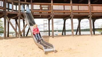 Enjoy a fun day at the beach with a thrilling slide and scenic views of the surrounding forest and water.