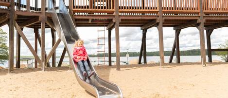 A wooden deck with a metal slide.