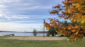 A grassy area with a beach and a body of water in the background.
