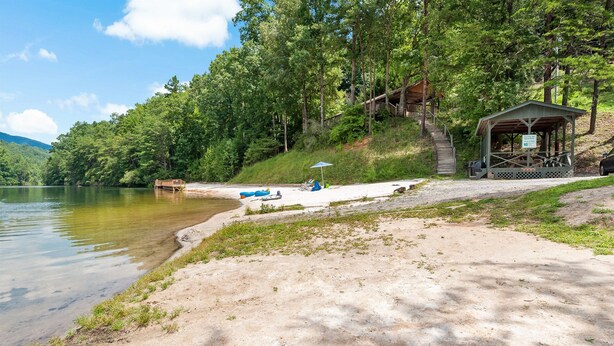 A lakeside cabin with a covered seating area and a dock. - Hot Tub, Mirror Lake Access, Log Cabin - Hawks Terrace by Carolina Properties (Lake Lure)