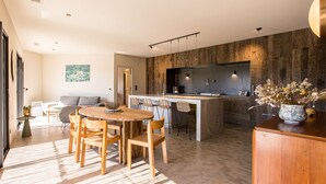 Eine moderne Küche mit einer zentralen Kochinsel, Holzkohle und einem Esstisch.
