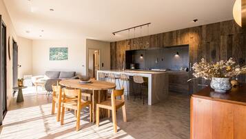 Une cuisine moderne avec un îlot central, des chaises en bois et une table à manger.