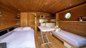 Eine Hütte mit zwei Betten, einer kleinen Küchenzeile und einem Fenster.
