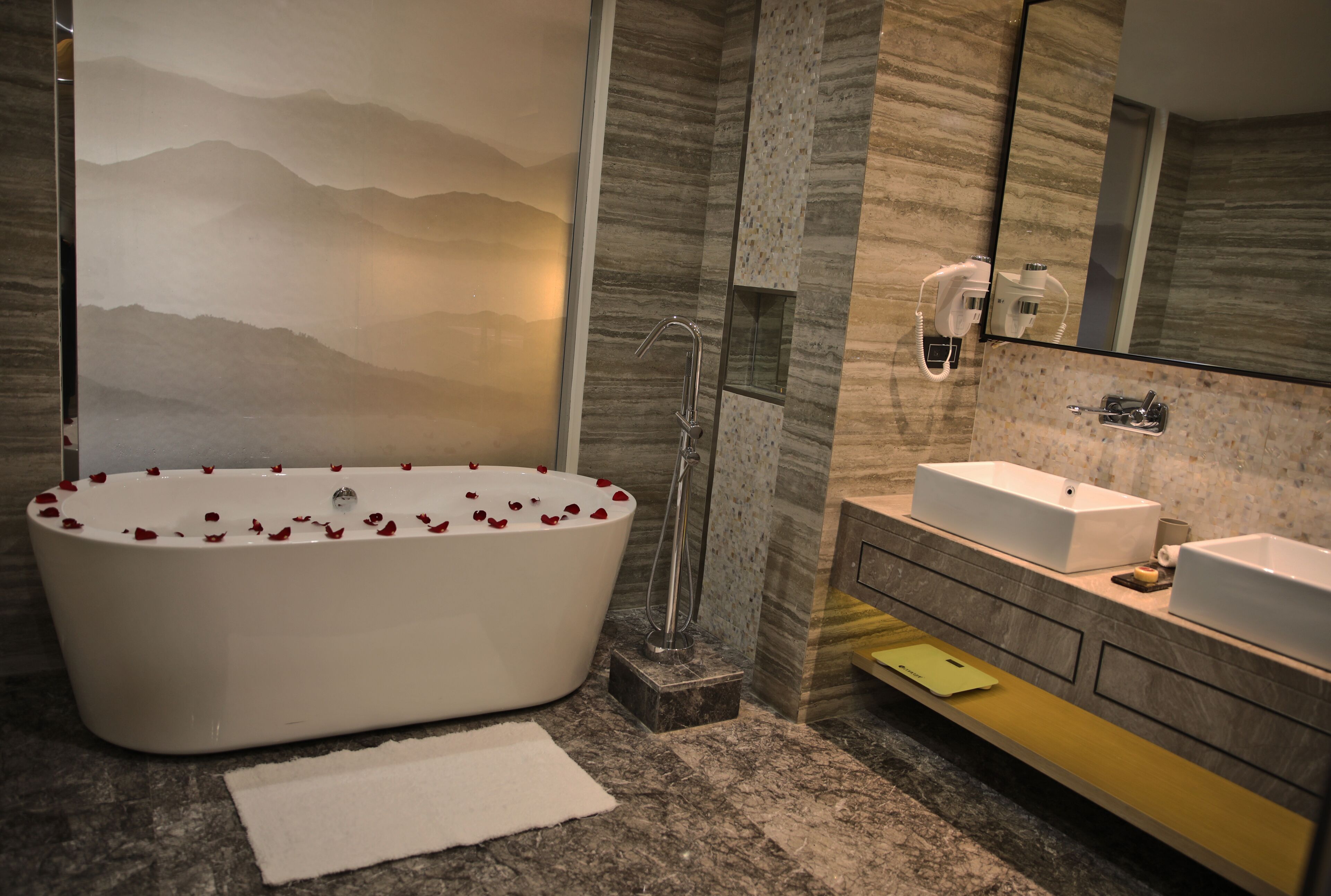 A modern bathroom with a freestanding bathtub, a large mirror, and a vanity with a sink.