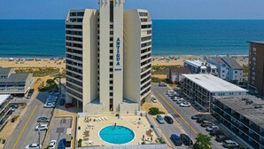 Un hotel con piscina, vistas a la playa y aparcamiento.