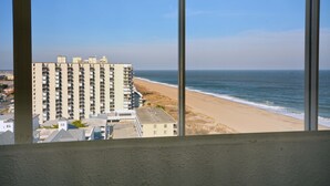 Un edificio alto con varios balcones que dan a una playa y al océano.