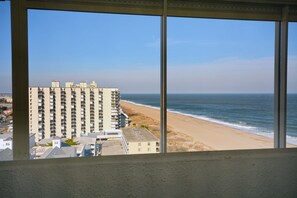 Un edificio alto con varios balcones que dan a una playa y al océano.
