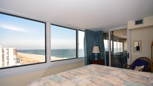 Habitación de hotel con un amplio ventanal que ofrece vistas a la playa y al océano.