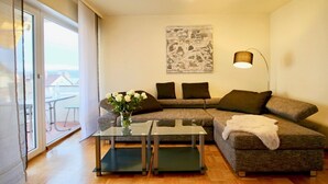 A modern living room with a sectional sofa, a glass coffee table, and a painting on the wall.