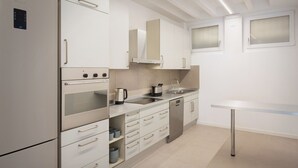 Una cocina moderna con electrodomésticos de acero inoxidable, armarios blancos y un diseño minimalista.