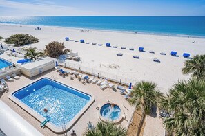 Un complexe hôtelier doté d’une piscine, de chaises de plage et offrant une vue sur l’océan.