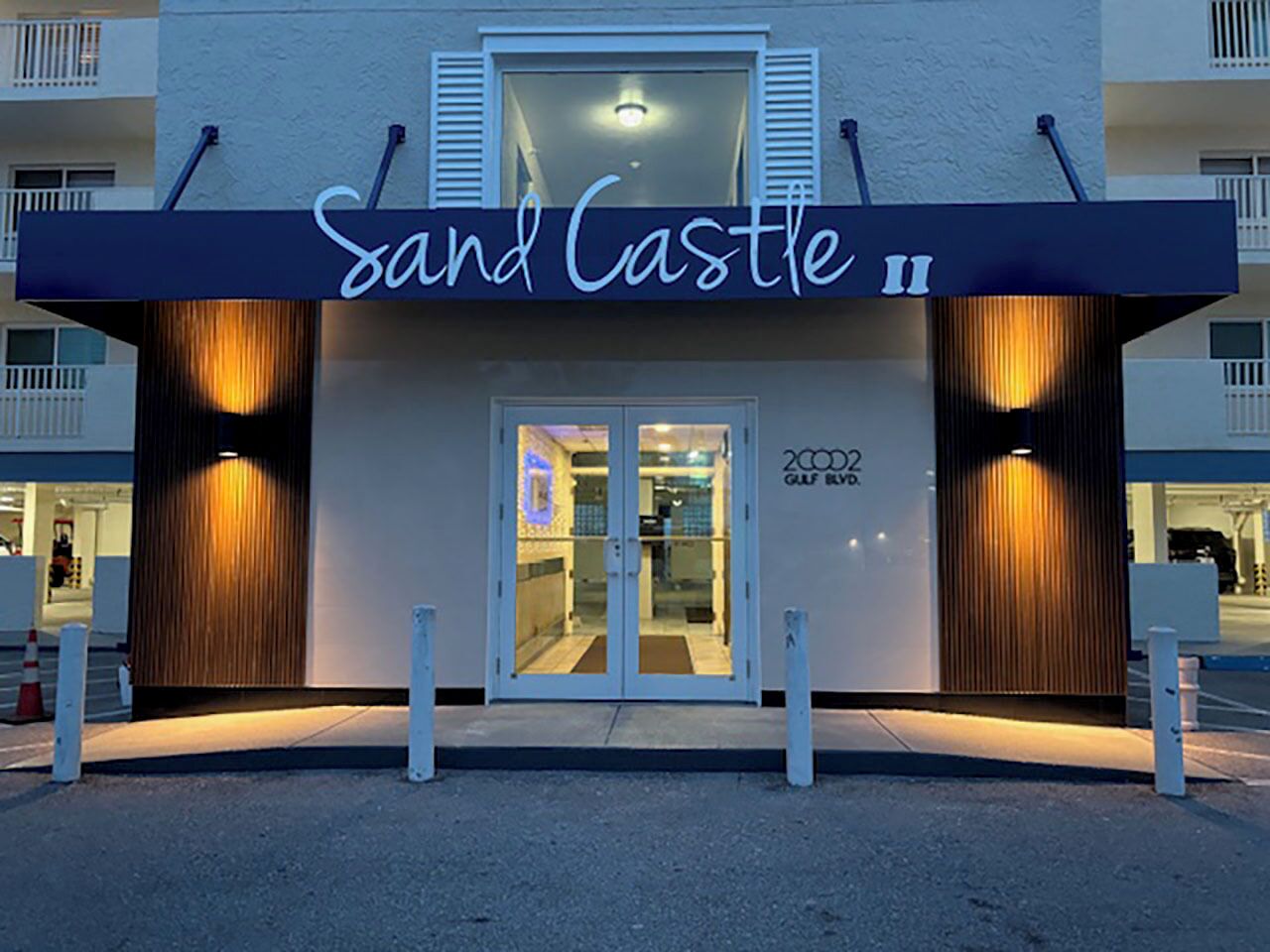 Entrada de hotel com uma placa que diz 'Sand Castle'.