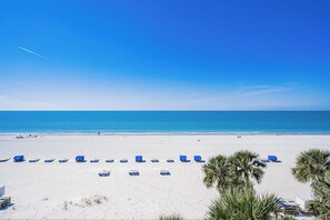 A beach with white sand, a clear blue sky, and a calm sea. - Sand Castle II 505 - GULF FRONT Condo! (Indian Shores)
