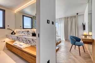 Un bagno moderno con un vanità in marmo, un armadietto in legno e uno specchio grande.