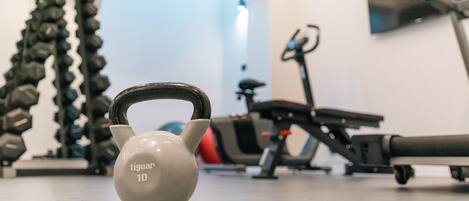 A kettlebell in a gym with exercise equipment in the background.