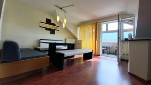 A modern living room with a sofa, a coffee table, and a dining area with a table and chairs. - Poludnig, cozy 5 P apartment (Presseggersee)