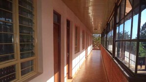 A corridor with large windows on one side and doors on the other.