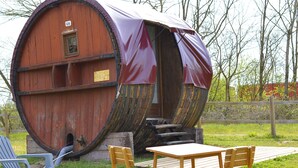 Un edificio con forma de barril, un letrero que dice "Givry", una mesa de madera y dos sillas al frente.