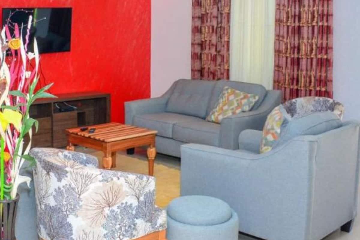 A living room with a grey sofa, a wooden coffee table, and a patterned armchair.