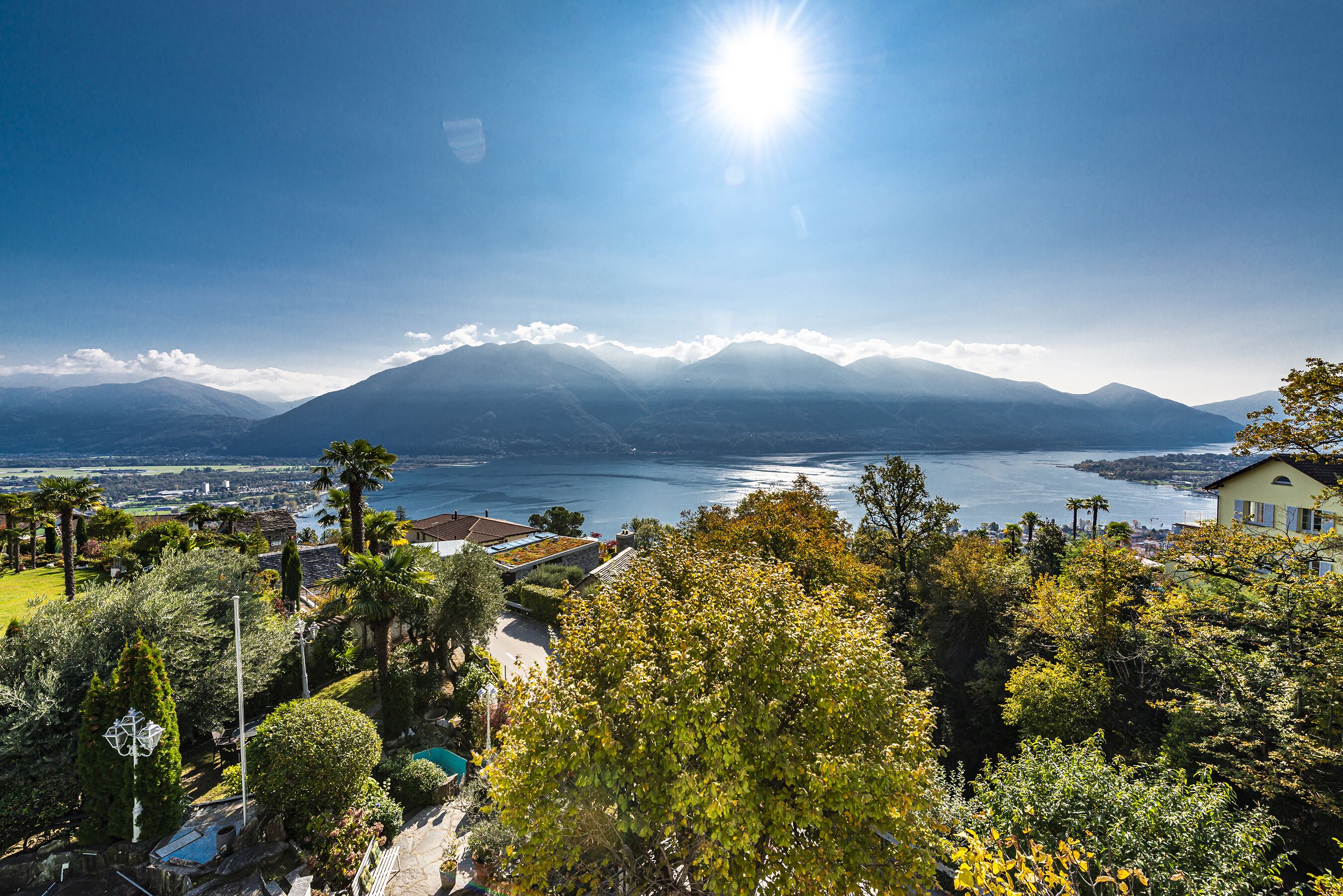 A mountainous landscape with a lake, a pool, and a house with a view.