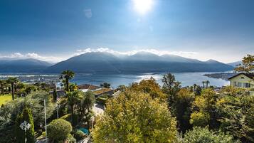 A mountainous landscape with a lake, a pool, and a house with a view.