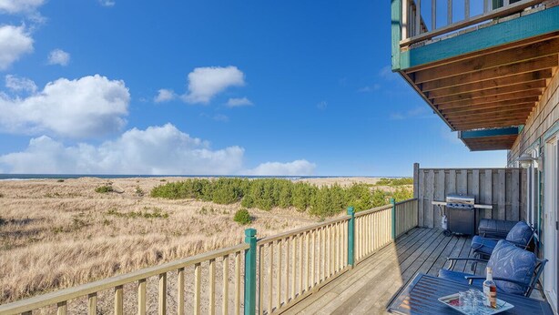 A wooden deck with outdoor seating, a grill, and a view of the beach and dunes. - OCEAN FRONT, Pets OK, Ping Pong, Near Town and Discovery Trail (Ocean View B) (Long Beach)