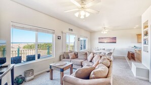 A spacious living room with a large sofa, a dining area, and a view of the ocean. - OCEAN FRONT, Pets OK, Ping Pong, Near Town and Discovery Trail (Ocean View B) (Long Beach)
