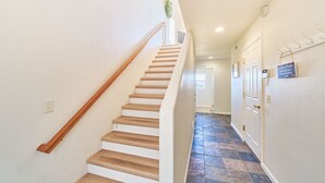A staircase with wooden steps and a handrail, leading to a door labeled 'Laundry.' - OCEAN FRONT, Pets OK, Ping Pong, Near Town and Discovery Trail (Ocean View B) (Long Beach)