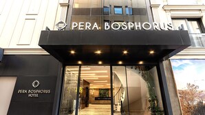 The entrance of the Pera Bosphorus Hotel with a modern facade, glass doors, and a visible staircase leading to the interior. - Pera Bosphorus Hotel (Istanbul)
