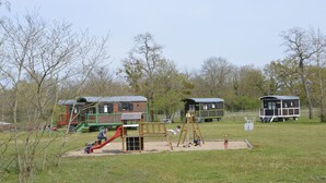 A playground with a slide, swings, and a sandbox. - Bohemian caravan (Chassenard)