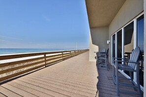 Relax on the deck with ocean views, surrounded by comfortable seating and tables.
