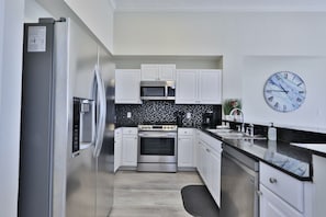 Enjoy cooking in this well-equipped kitchen with a refrigerator, oven, and microwave.