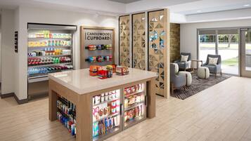 Un interior modern amb un armari Candlewood, una vitrina refrigerada per a begudes i zona d'estar amb vistes.